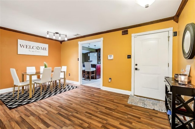 dining area featuring track lighting, light hardwood / wood-style floors, and ornamental molding