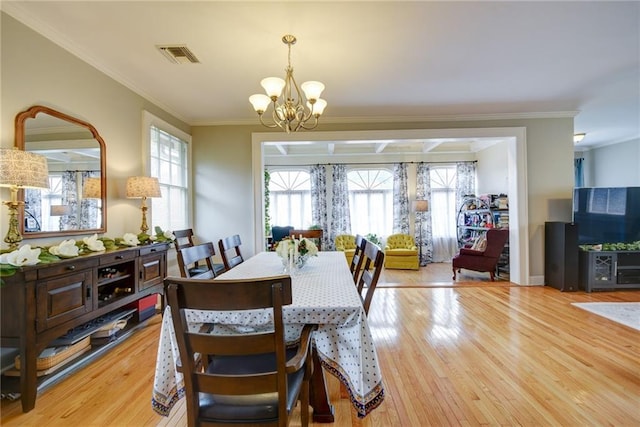 dining room featuring a wealth of natural light, ornamental molding, and light wood-type flooring