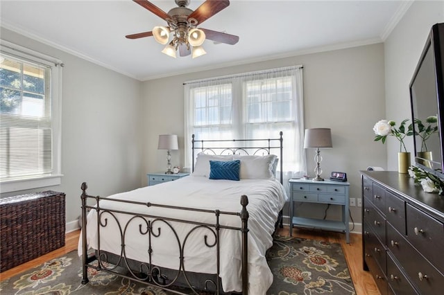 bedroom with ceiling fan, dark wood-type flooring, and ornamental molding