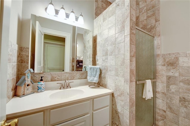 bathroom featuring tile walls, an enclosed shower, and vanity