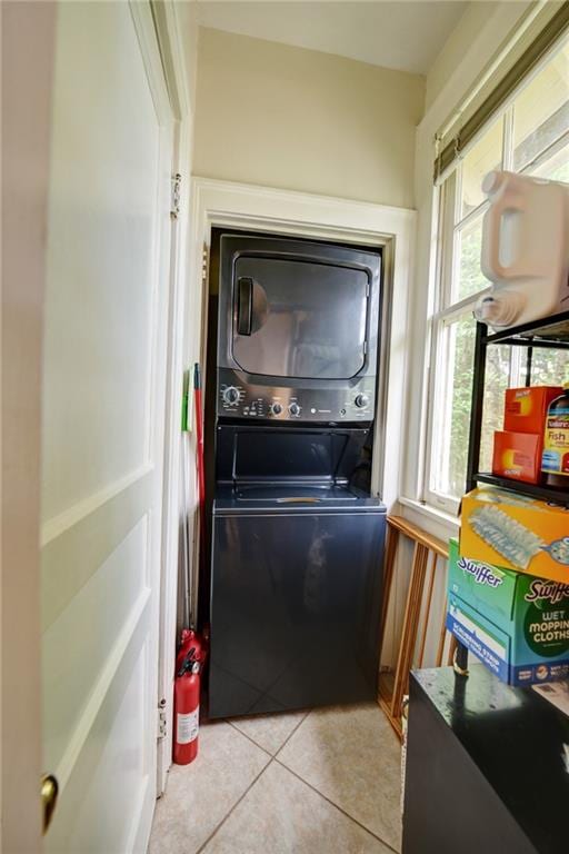 washroom featuring light tile patterned floors and stacked washer and clothes dryer