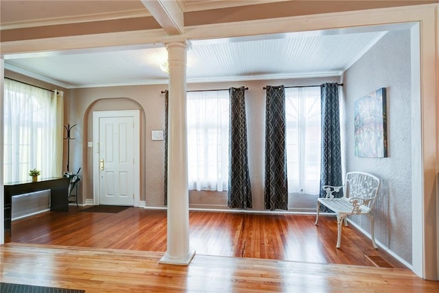 foyer with crown molding, hardwood / wood-style floors, and decorative columns