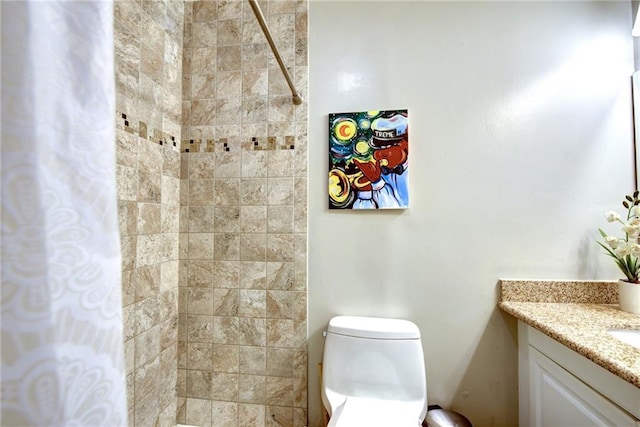 bathroom featuring toilet, vanity, and a shower with curtain