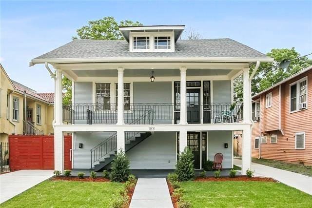 1831 S Dupre St, New Orleans, LA 70125 - view of front facade with covered porch, a front yard, and stairs