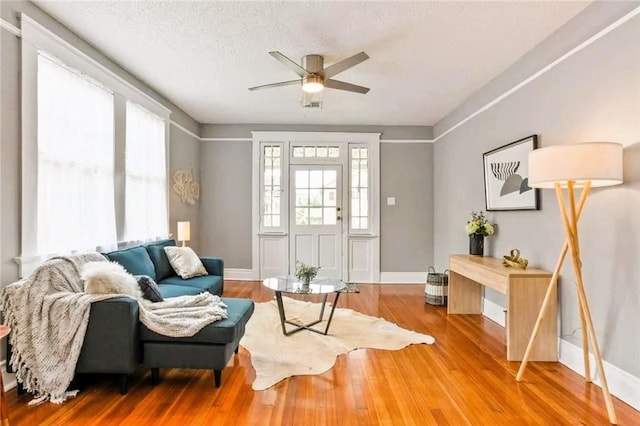 1831 S Dupre St, New Orleans, LA 70125 - living area with baseboards, a ceiling fan, wood finished floors, and a textured ceiling