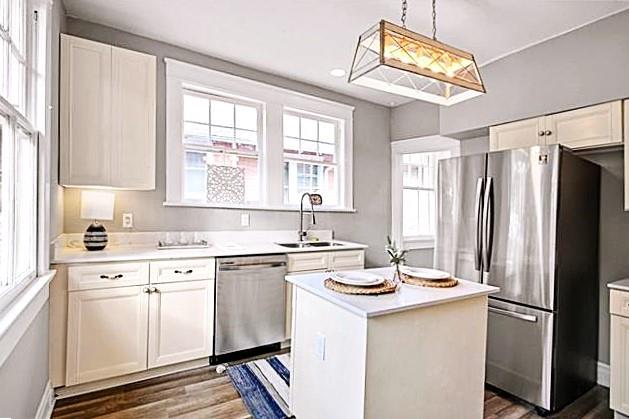 kitchen featuring a healthy amount of sunlight, pendant lighting, appliances with stainless steel finishes, and a kitchen island