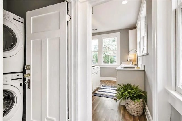 1831 S Dupre St, New Orleans, LA 70125 - laundry room with laundry area, light wood-type flooring, a sink, stacked washing maching and dryer, and baseboards