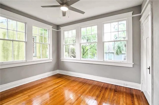 unfurnished sunroom featuring ceiling fan