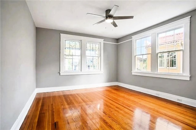1831 S Dupre St, New Orleans, LA 70125 - spare room with wood-type flooring, ceiling fan, baseboards, and a healthy amount of sunlight