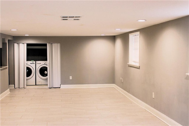 clothes washing area featuring independent washer and dryer and light hardwood / wood-style floors