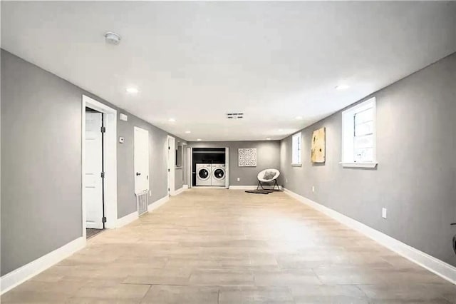 basement with washing machine and dryer and light hardwood / wood-style floors