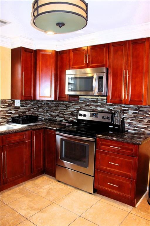 1831 N Miro St, New Orleans, LA 70119 - kitchen featuring stainless steel appliances, tasteful backsplash, dark brown cabinets, and dark stone counters