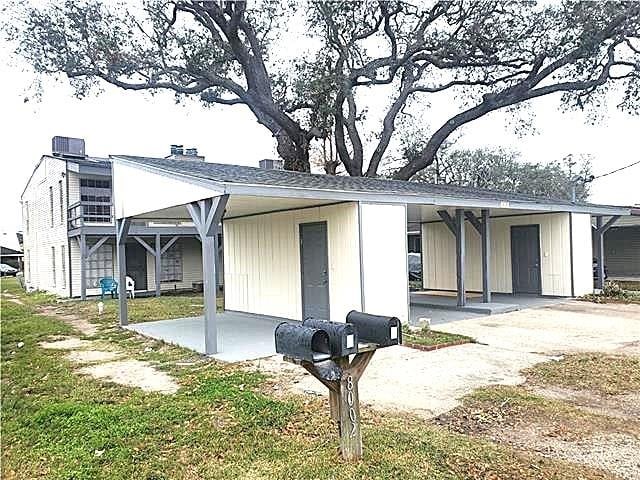 back of house featuring a carport