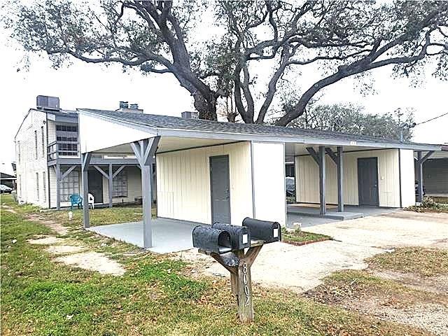 8002 Trapier Ave, New Orleans, LA 70127 - back of house featuring central air condition unit, a carport, a chimney, and a lawn
