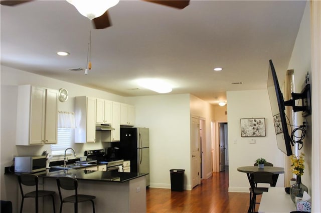 6226 Lafaye St, New Orleans, LA 70122 - kitchen with stainless steel electric range oven, ceiling fan, dark countertops, a sink, and under cabinet range hood