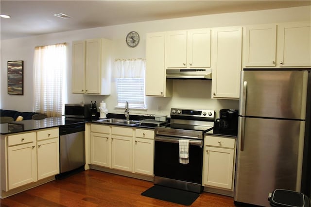 6226 Lafaye St, New Orleans, LA 70122 - kitchen featuring dark countertops, a sink, a peninsula, under cabinet range hood, and stainless steel appliances
