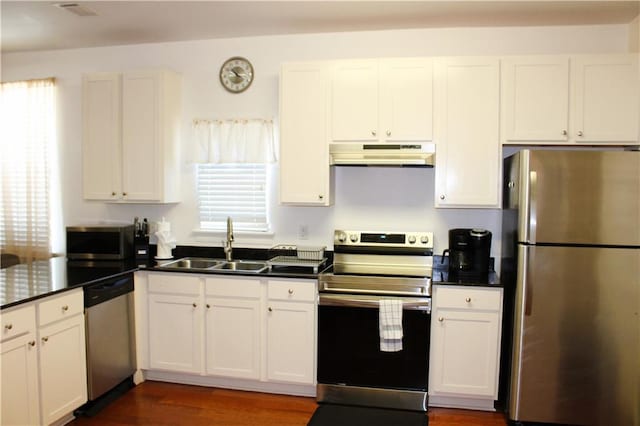 kitchen with dark hardwood / wood-style flooring, stainless steel appliances, sink, and white cabinetry