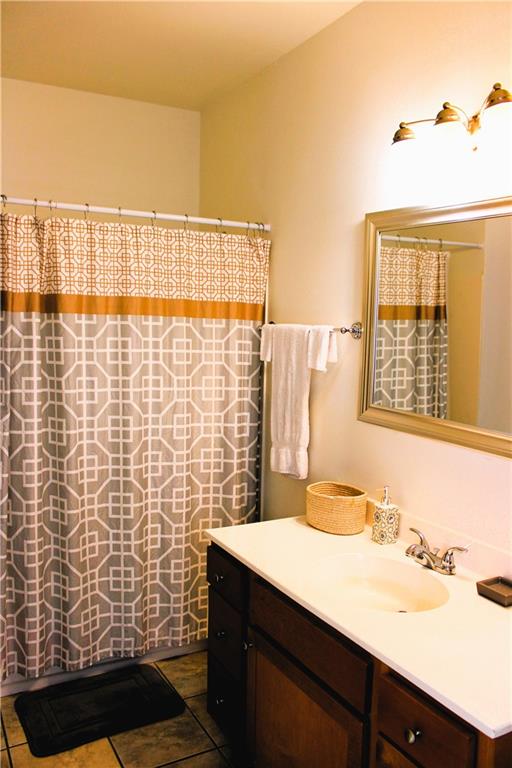 bathroom with tile patterned flooring, vanity, and curtained shower