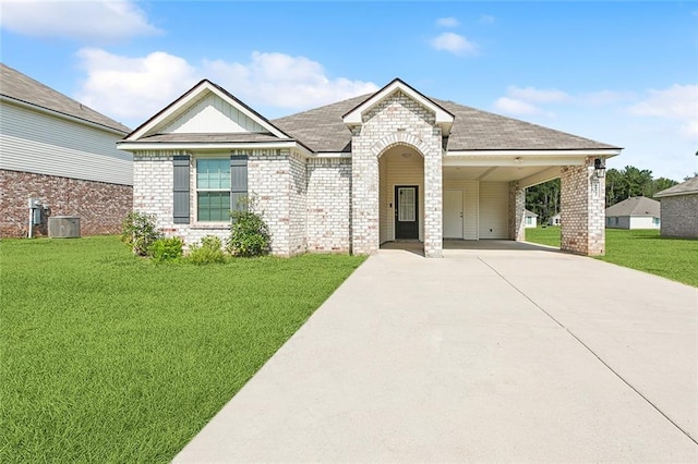 view of front of property with an attached carport, a front yard, concrete driveway, and brick siding