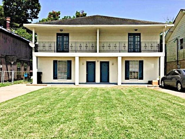 exterior space featuring a balcony and a front lawn