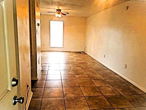 tiled empty room with ceiling fan