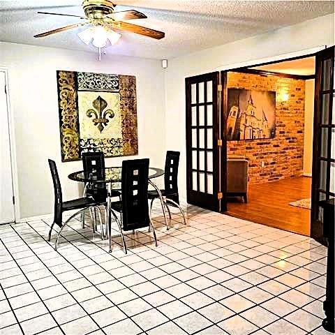 dining space with a textured ceiling, ceiling fan, and light wood-type flooring