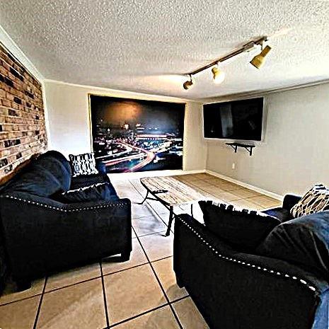 tiled living room featuring rail lighting and a textured ceiling