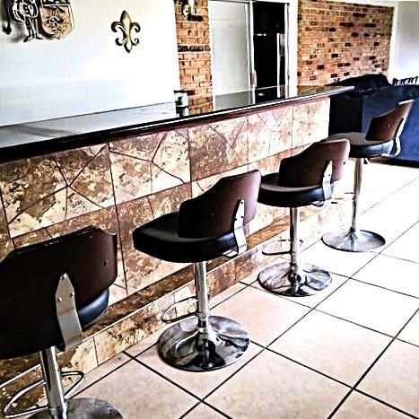 bar with stainless steel fridge and tile patterned floors