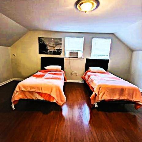 bedroom featuring dark wood-type flooring and vaulted ceiling