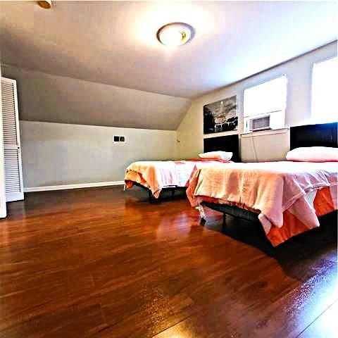 bedroom with dark wood-type flooring, cooling unit, and vaulted ceiling