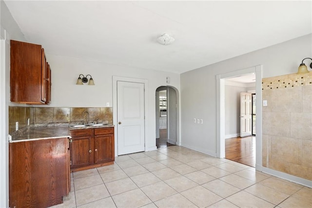 kitchen featuring sink, light wood-type flooring, and tasteful backsplash