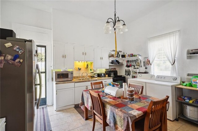 dining area featuring sink, washer and dryer, light tile patterned flooring, and a chandelier