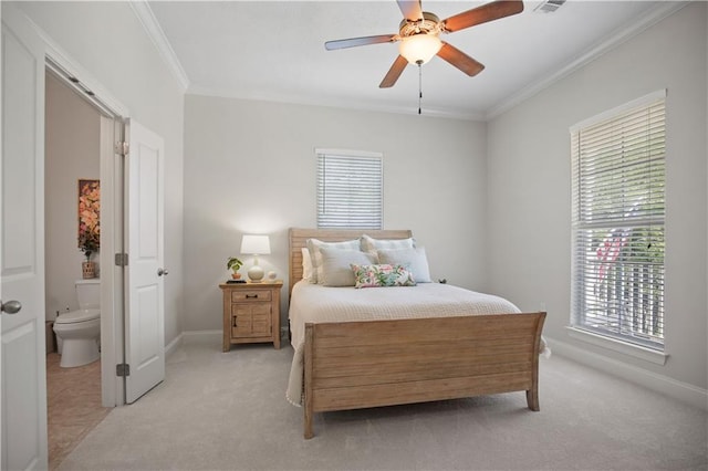 bedroom featuring ceiling fan, light colored carpet, ensuite bath, and ornamental molding