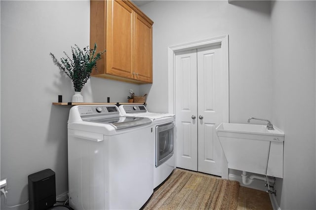 laundry room featuring cabinets, sink, and independent washer and dryer