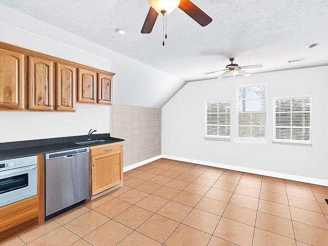 kitchen with lofted ceiling, ceiling fan, dishwasher, sink, and white oven