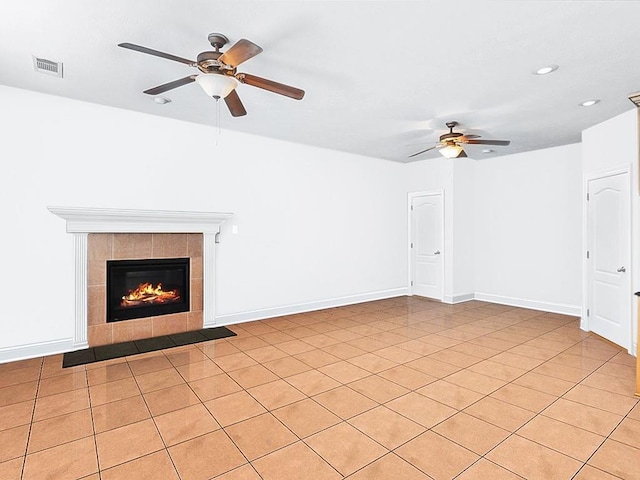 unfurnished living room featuring ceiling fan, a tile fireplace, and light tile patterned flooring