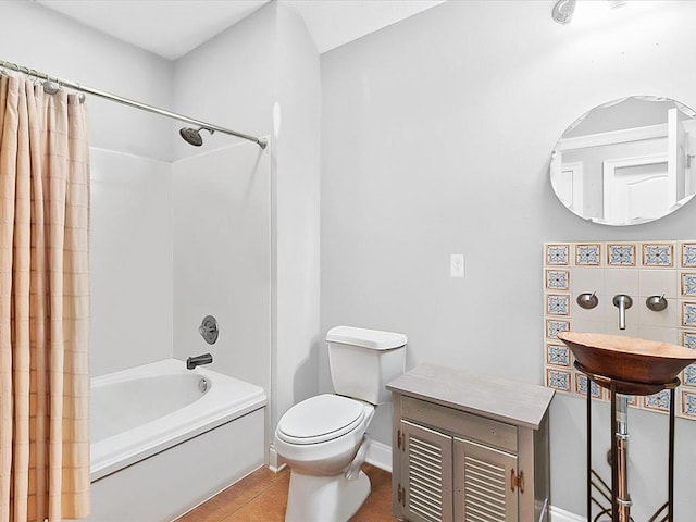 full bathroom with toilet, backsplash, tile patterned floors, shower / tub combo, and sink