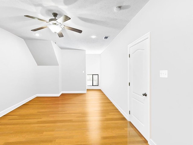 empty room featuring ceiling fan, a textured ceiling, and light wood-type flooring