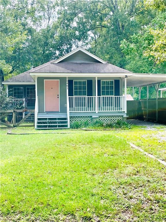 view of front of property featuring a front yard, a porch, and a carport