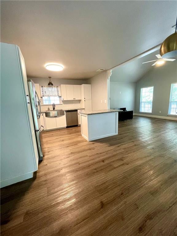 kitchen with ceiling fan, wood-type flooring, white cabinetry, lofted ceiling, and stainless steel appliances