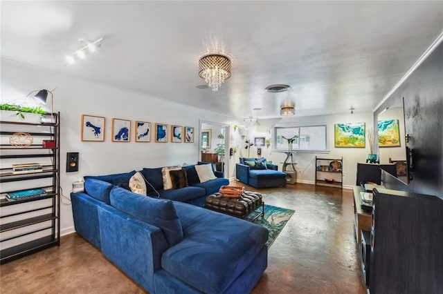 living room with a notable chandelier and concrete flooring