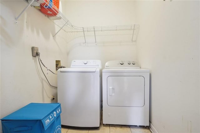 washroom featuring washing machine and dryer and light tile patterned floors