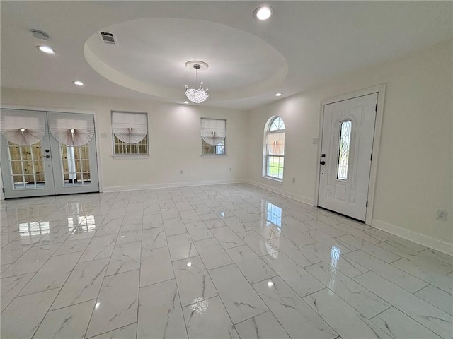 entryway with marble finish floor, baseboards, a raised ceiling, and recessed lighting