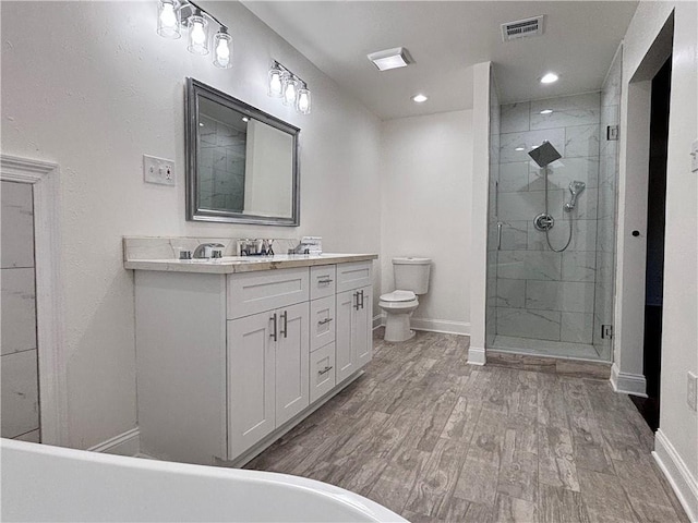 full bathroom with a stall shower, visible vents, toilet, and wood finished floors