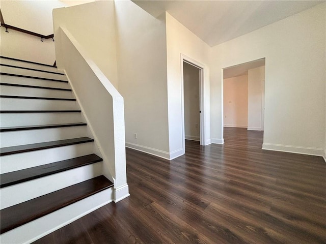 staircase featuring baseboards and wood finished floors