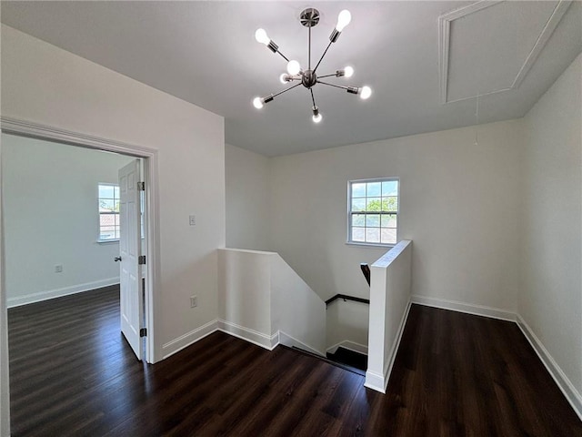 stairs featuring attic access, baseboards, and wood finished floors