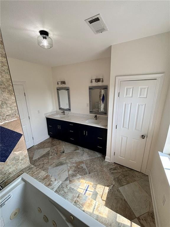 full bath featuring visible vents, a jetted tub, baseboards, and double vanity