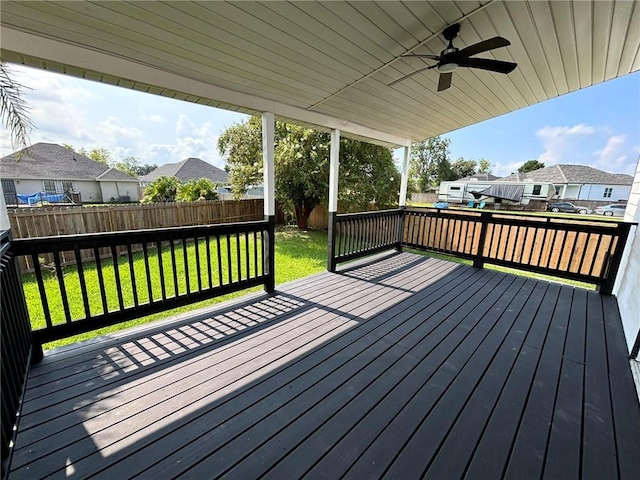 wooden terrace with a residential view, a fenced backyard, a yard, and ceiling fan