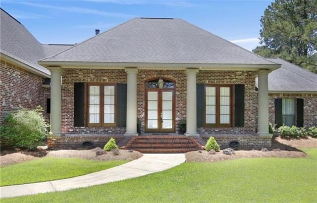 exterior space with a lawn, french doors, and a porch