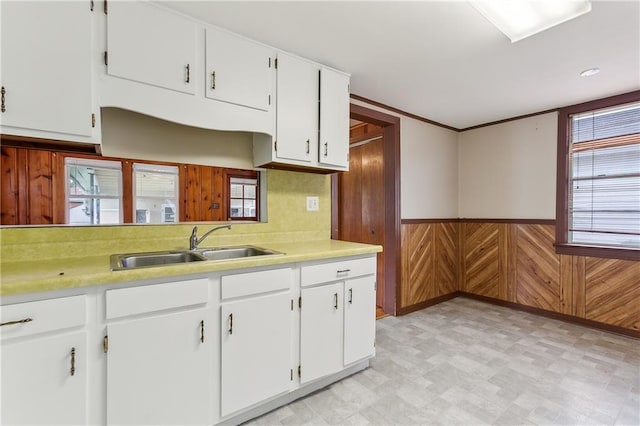 kitchen featuring white cabinets, decorative backsplash, sink, and light tile patterned floors